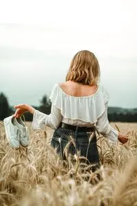 Blond women walking barefoot in the wheat field